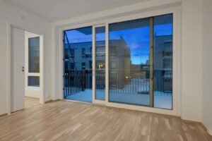 Modern empty room with a large sliding glass door opening to a balcony